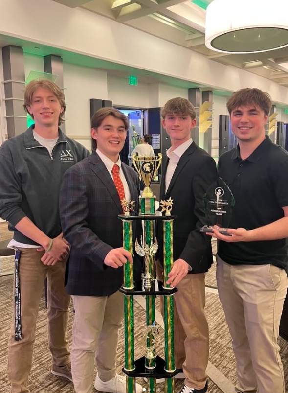 Delta Chi members holding the MSU Greek Week first-place trophy